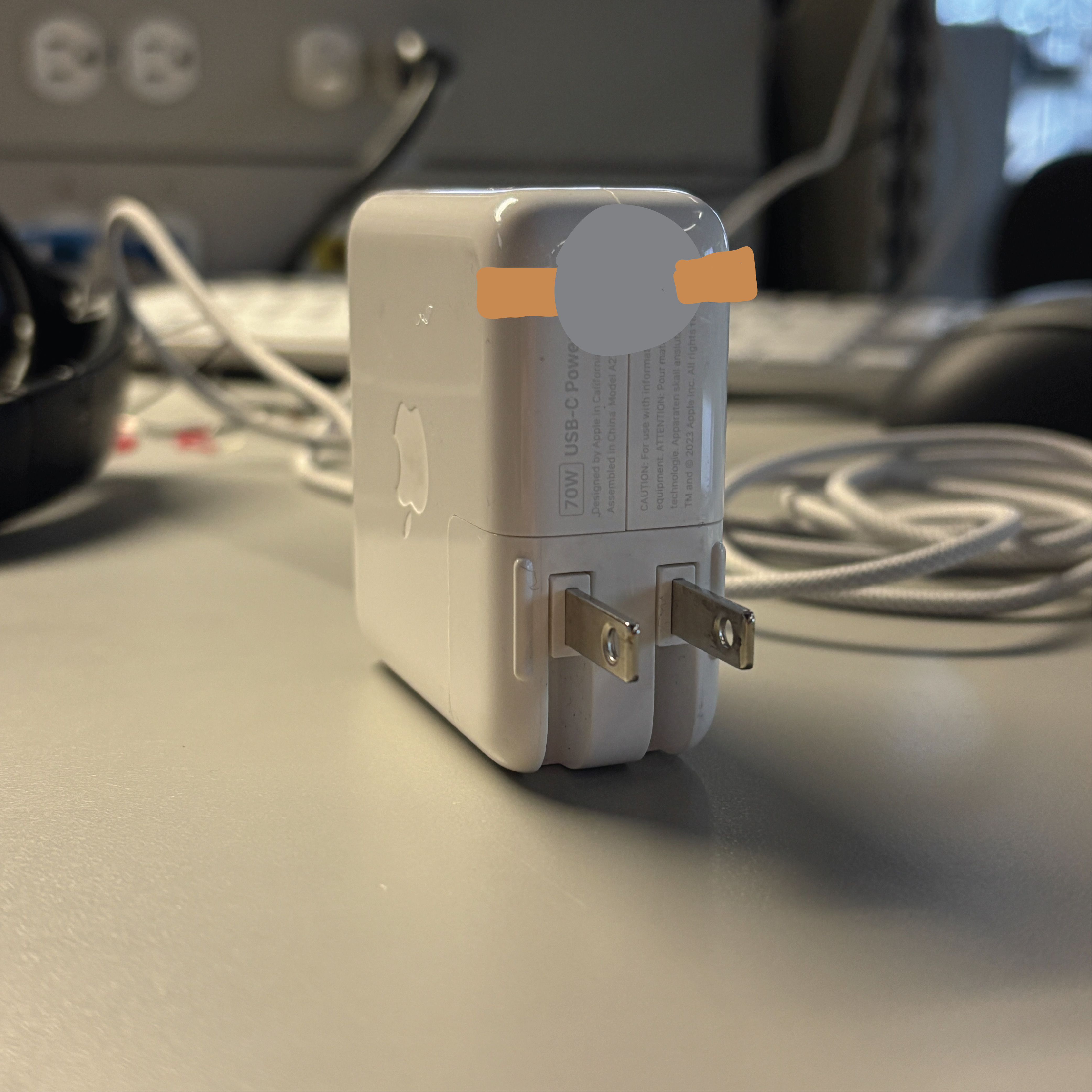 A circuit that shows a non-wearable circuit that closes as the mac charger gets plugged into the wall, causing the LED to activate as the copper tape and battery allows current to flow to the circuit on the wall.